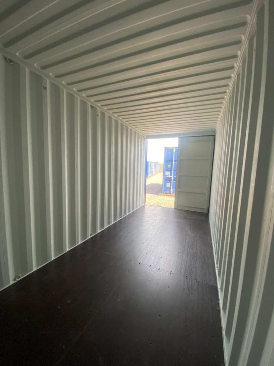 Looking down the inside of an empty Containastore container, doors open onto the yard